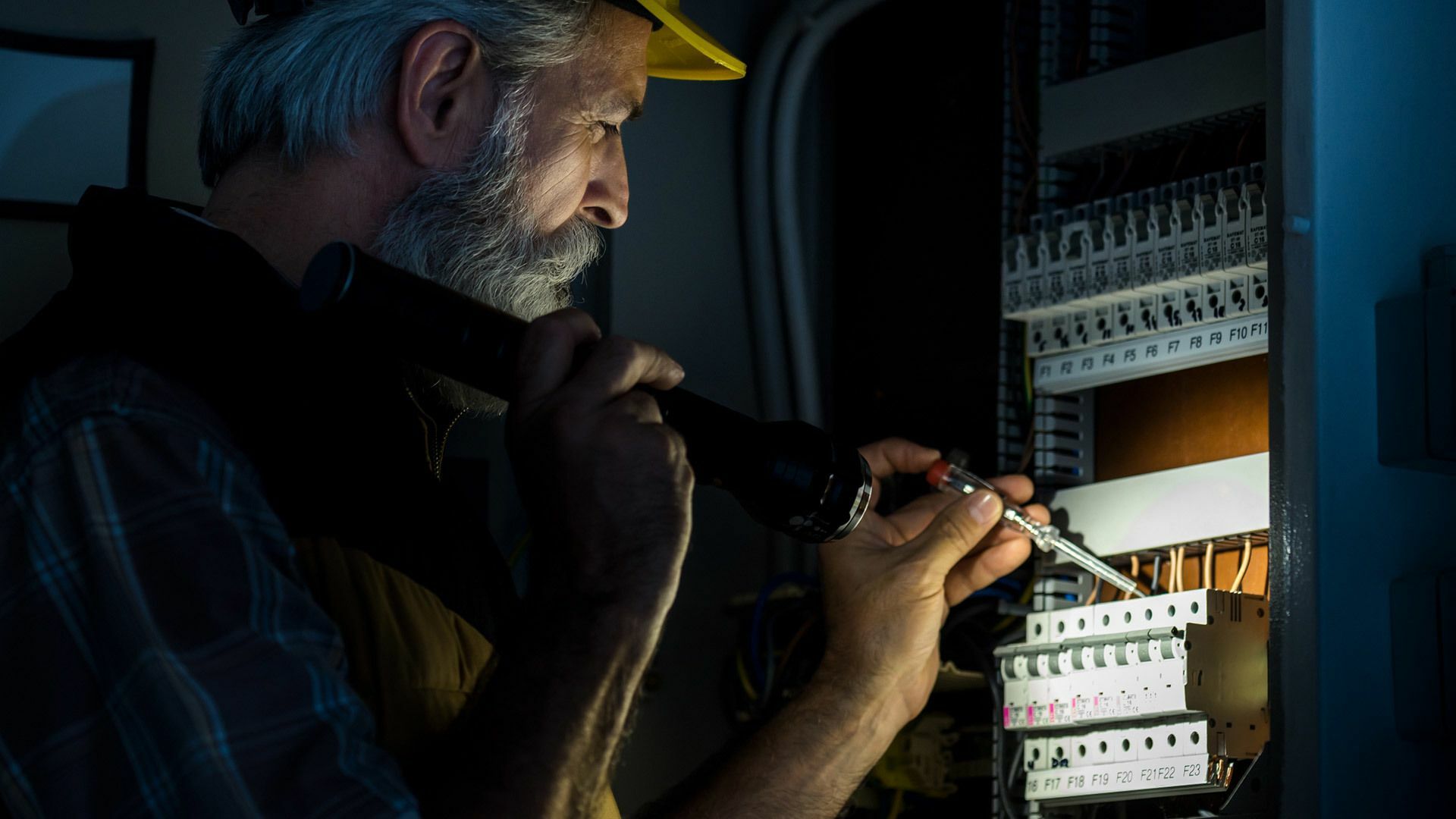 Elektriker durchleuchtet Stromkasten