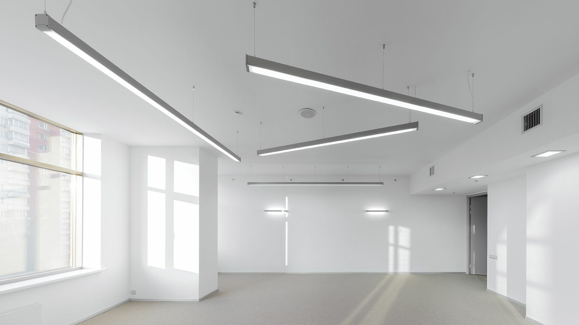 Innenbeleuchtung. Leerer Büroraum mit Design-Leuchten and der Decke